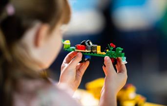 A small child playing with lego