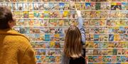Child pointing at wall of book covers