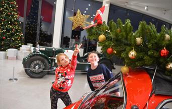 Kids pointing at elf in motor museum