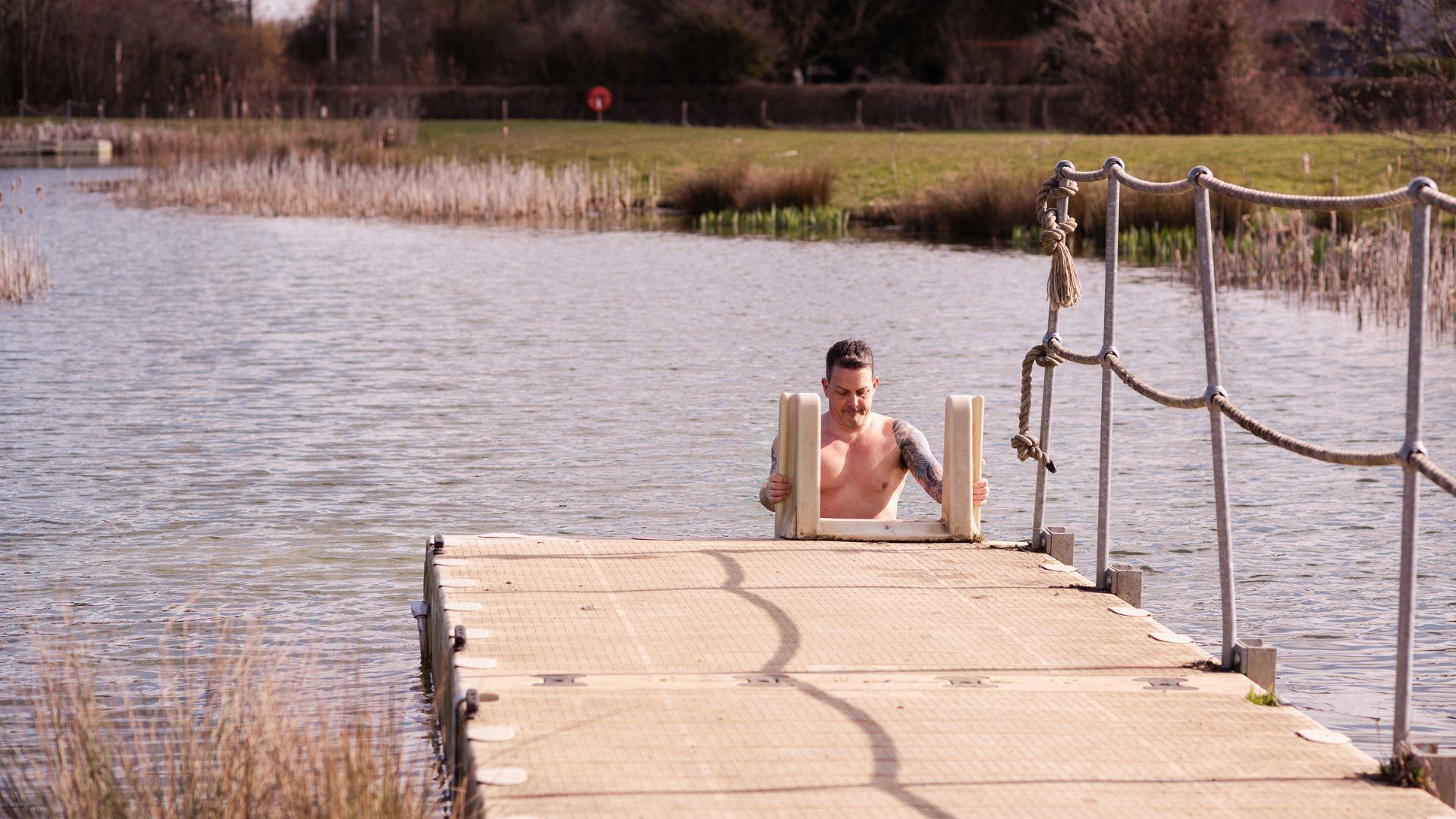 Man emerging from wild swim lake