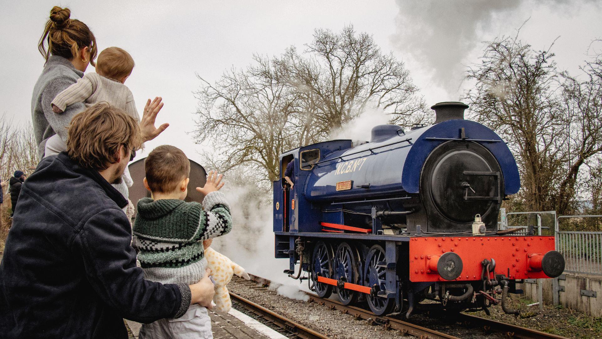 Family waving at steam train on Avon Valley Railway