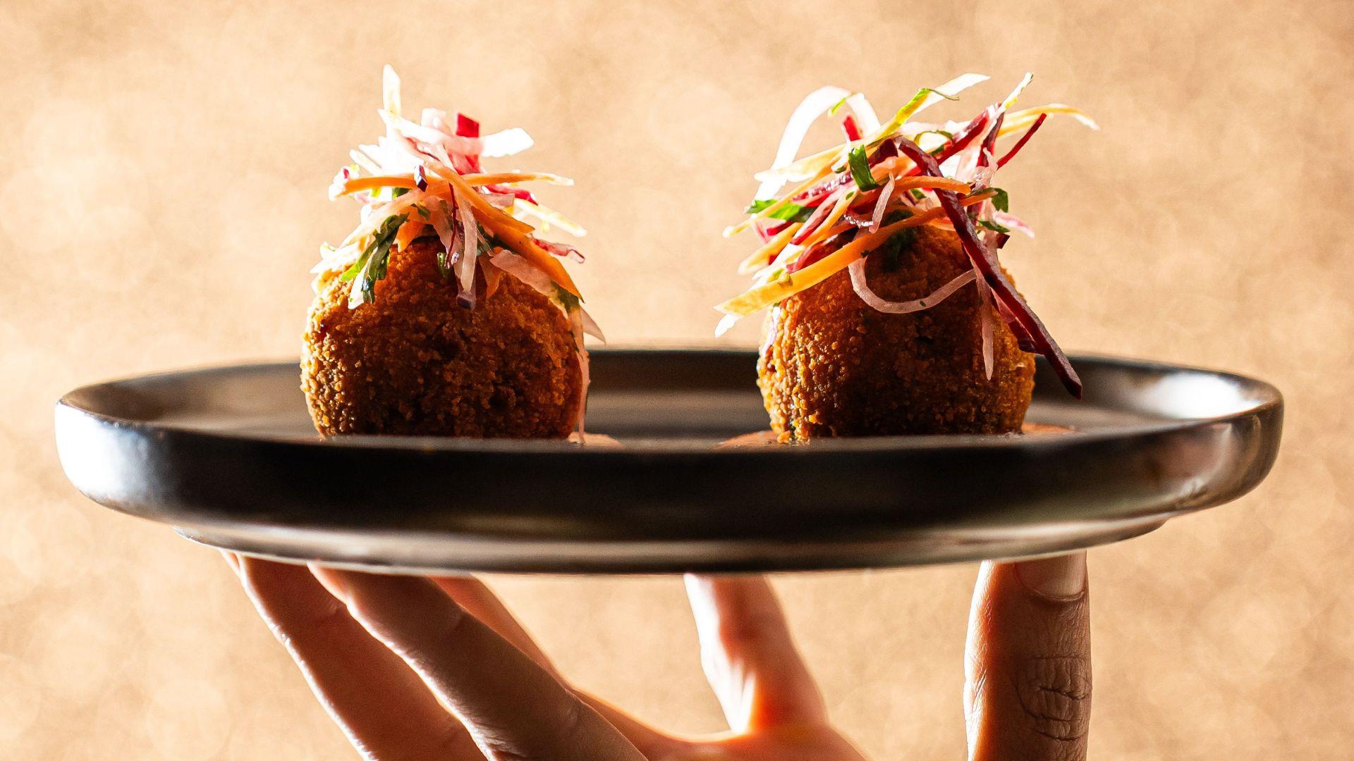 Hand holding snacks on plate