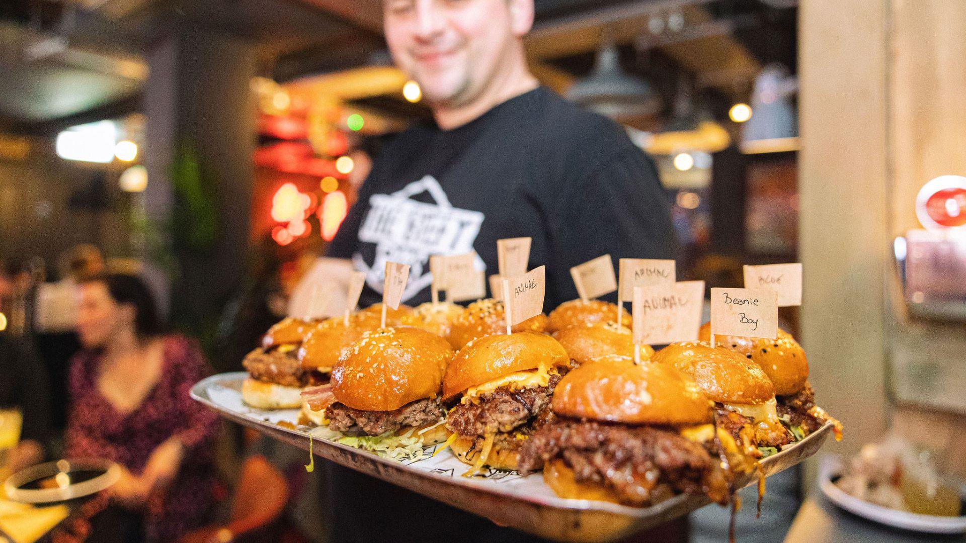 Man holding tray of burgers