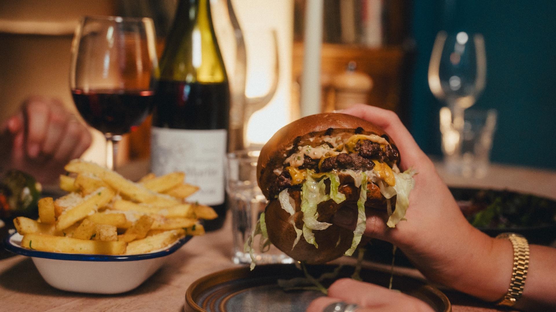 A burger and a glass of wine on a table at Green Park Brasserie in Bath.