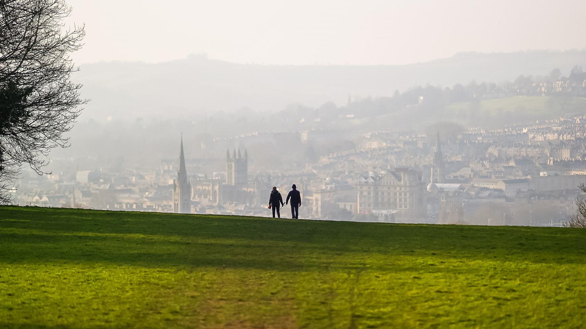 Silhouette couple on hill overlooking city