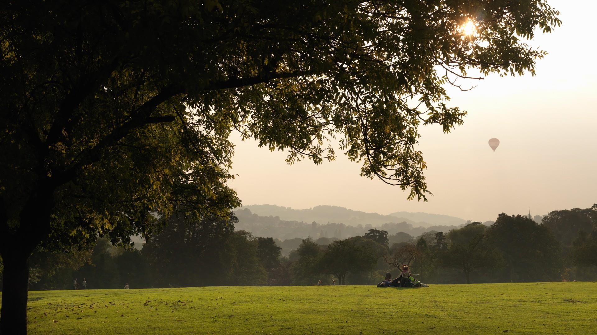 A single hot air balloon flies above Royal Victoria Park