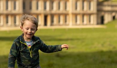 Boy running in front of a historic house