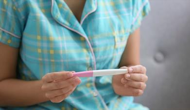 Woman holding a pregnancy test