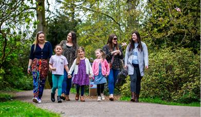 family walking through woodland in spring