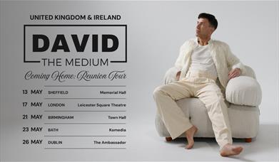 Poster for David The Medium Coming Home Reunion Tour with David in cream clothing, seated in a cream chair.