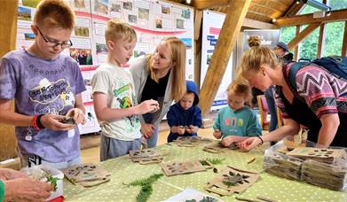 family completing craft activity around a table indoors