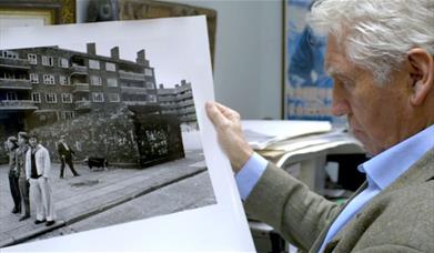 man looking at large black and white photograph