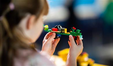 A small child playing with lego 