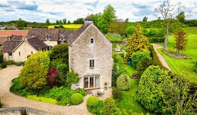 Dovecote Cottage's exterior surrounded by nature and forestry.