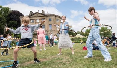 Image of Children hula hooping on the lawns outside the manor house