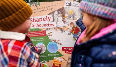 two children look at colourful Stick Man trail panel