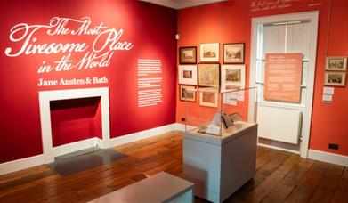 Exhibition room with red walls and white writing