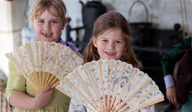 Two girls holding fans