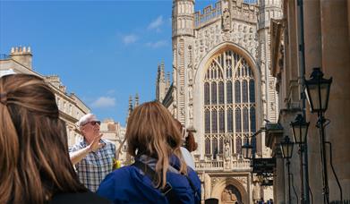 Tour guide discussing the Roman Baths while in front of the Cathedral