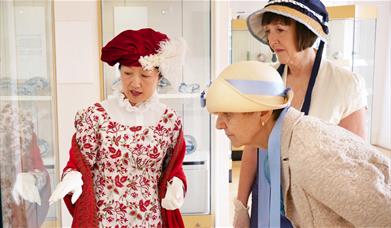 3 ladies dressed in regency wear 