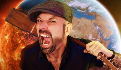 Jonny Cole shouting and holding a guitar in front of an Earth on fire