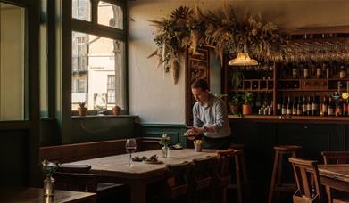 Interior of the Marlborough with tables being set and the bar behind