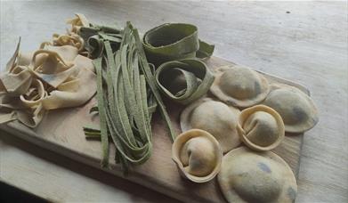 different types of pasta on a wood board