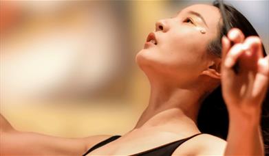 A young woman conducting. Sparkfest logo in top corner