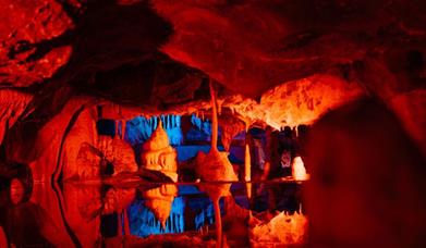 Cheddar Caves lit up in red and blue
