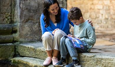 a woman and boy looking a paper trail