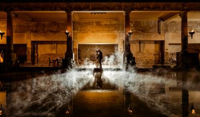 A newly married bride and groom alongside the Great Bath at The Roman Baths in Bath 