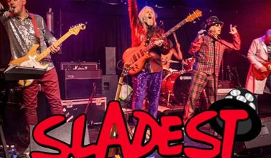 A photo of the band Sladest siing live on stage 