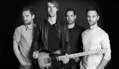 A black and white photo of the band. 