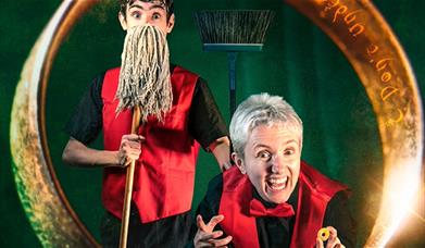 Two cinema ushers hold props that emulate The Lord of The Rings franchise. 