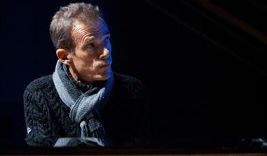 a man in a scarf in a dark room