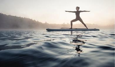Woman balancing on a surfboard in the sea