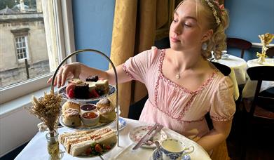 Lady having afternoon tea whilst dressed in period costume