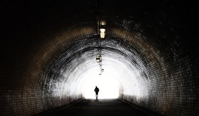 Man walking in backlit tunnel