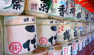 A colourful wall of large, round, traditional sake containers