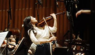 Female musician posing holding a violin