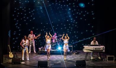 people dressed as abba, performing on a stage