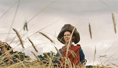 Still from film of a woman in a field