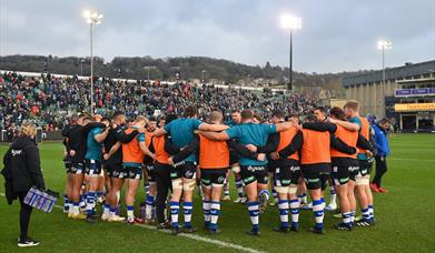 The Bath Rugby team huddle together during the pre-match warm-up.