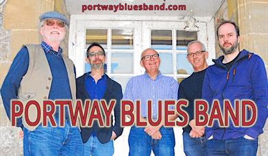 Four men standing in front of a door smiling, big red font in front reading 'Portway Blues Band'