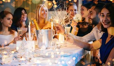 A group of people raising glasses of champagne at an elaborately decorated table