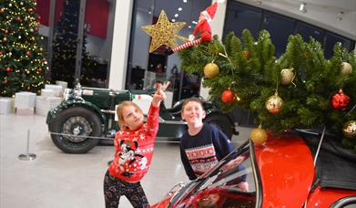 Kids pointing at elf in motor museum