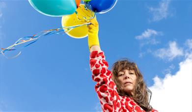 Woman holding balloons in the sky
