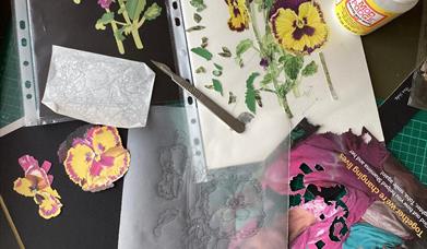 Image of a collage in process across a workspace