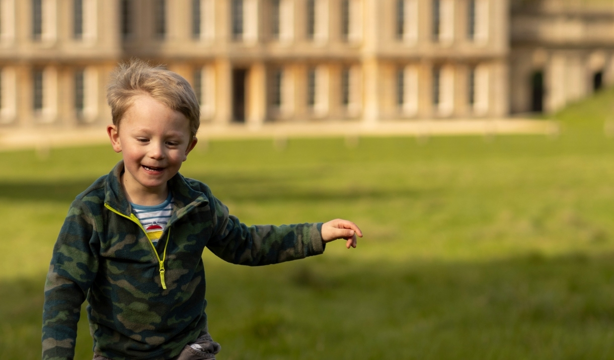Boy running in front of a historic house