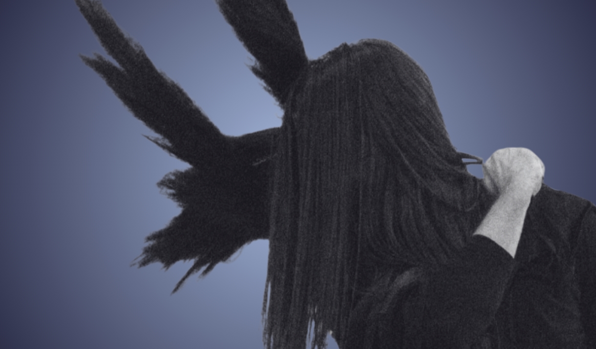 Silhouetted figure of a person with long dark hair covering their face, turned to the side, with some long dark feathers showing through behind their